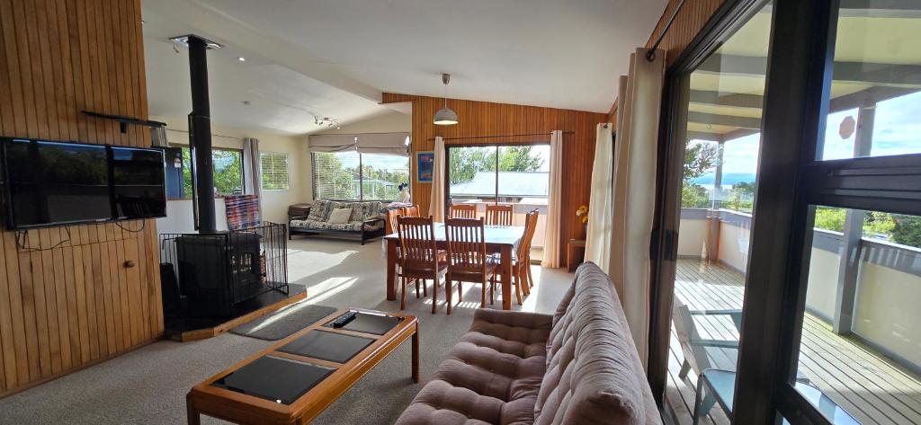 a living room with a couch and a tv and a table at Cagou's Bach in Kuratau