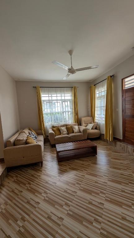 a living room with two couches and a table at Esther & Hans Homes in Dodoma