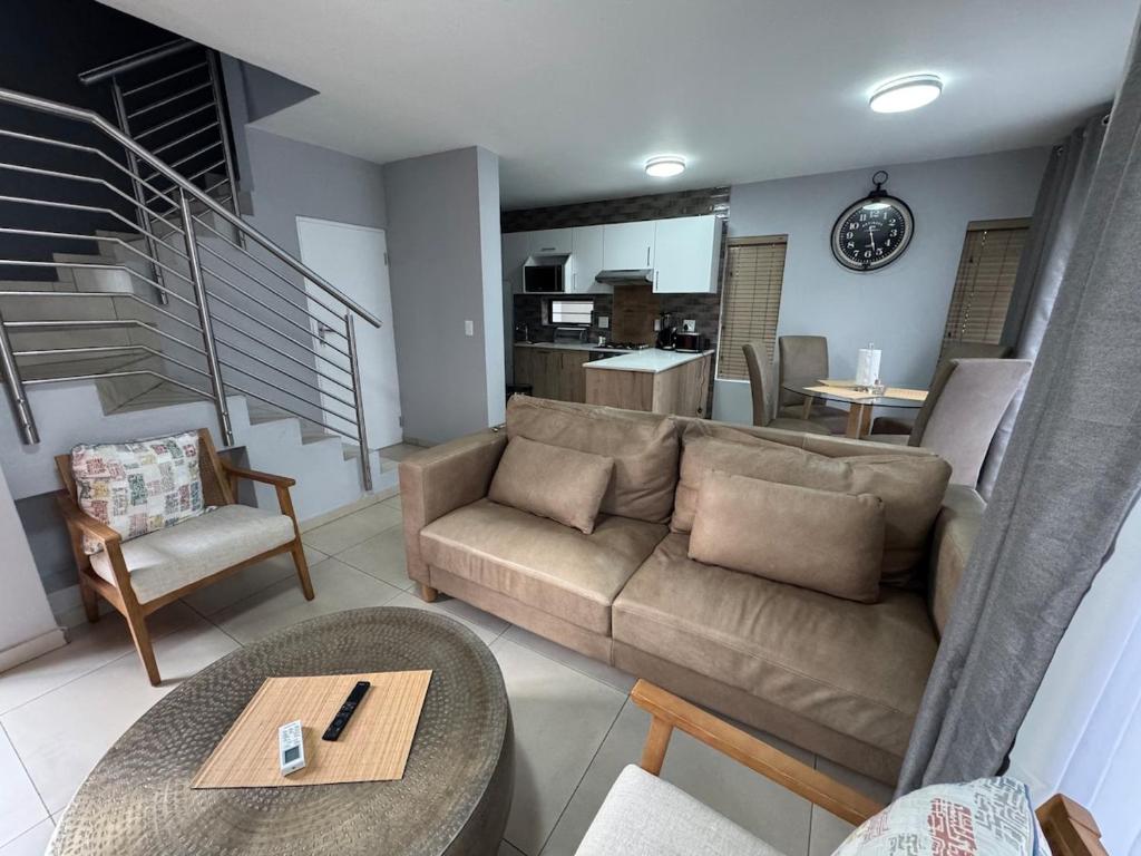 a living room with a couch and a table at Kheniyas Haven in Nelspruit