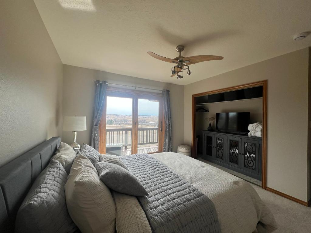 a bedroom with a bed with a ceiling fan and a window at Bayou Hills BnB in Parker