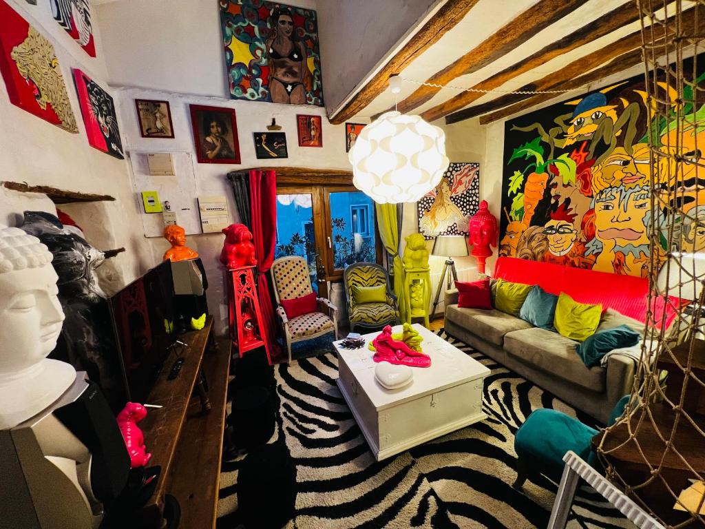 a living room filled with lots of colorful furniture at Maison de charme du 18 e s de centre ville in Sablé-sur-Sarthe