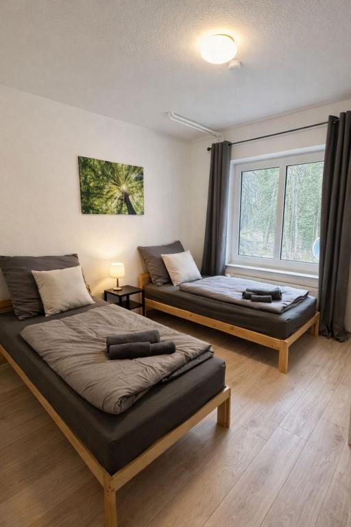 a bedroom with two beds and a window at Die ANS Group Cozy Apps in Detmold