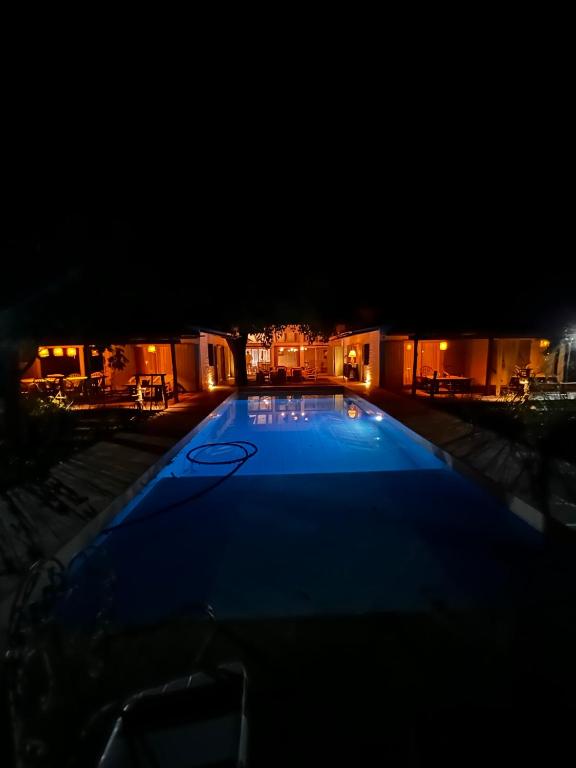a large blue swimming pool at night at Momocho in Esquina