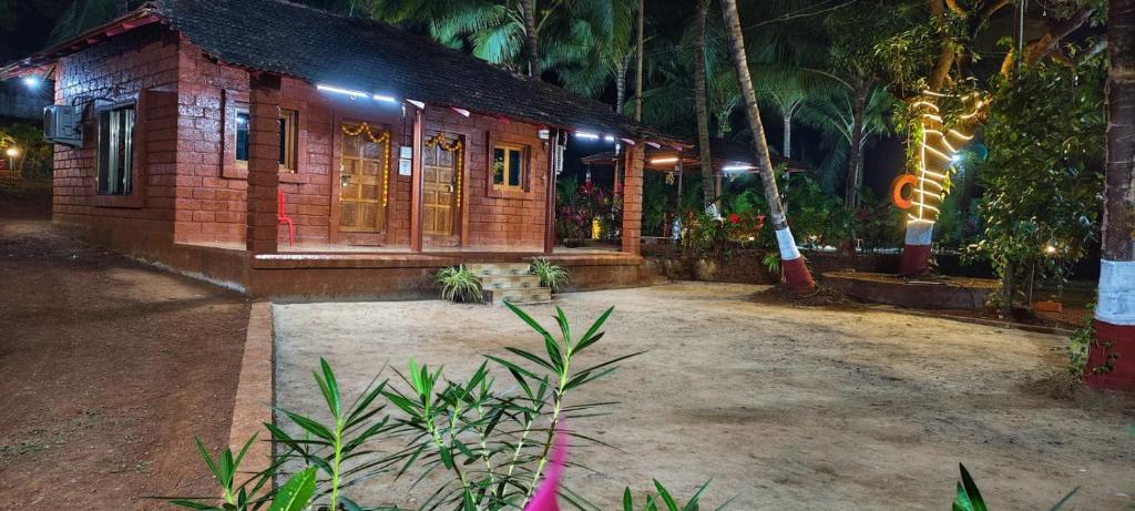 a small house with lights on it at night at Varsha farm house in Guhagar