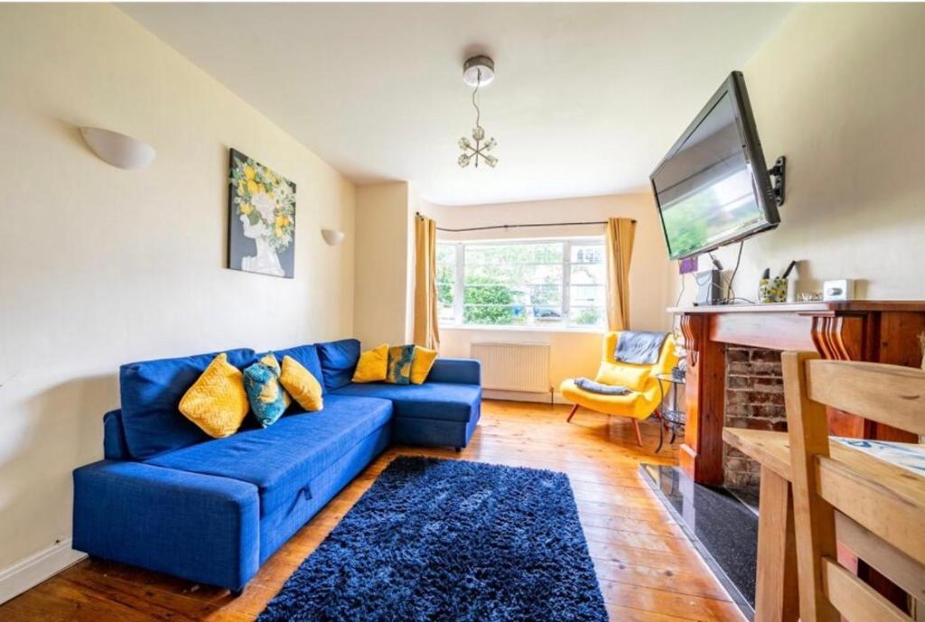 a living room with a blue couch and a tv at Sand-Ring-Ham in Moortown