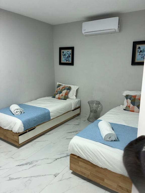 two beds in a room with white walls at Beit Shemesh gimmel apartment in Beit Shemesh