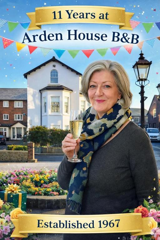 a woman holding a glass of champagne in front of a house at Arden House in Arundel