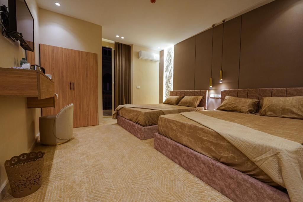 a hotel room with two beds and a couch at Sydney DownTown-Cairo in Cairo