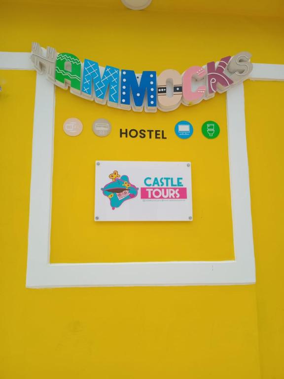 a sign that readsanimal hospital castle tours on a yellow wall at Hammocks - Hamacas in Ríohacha