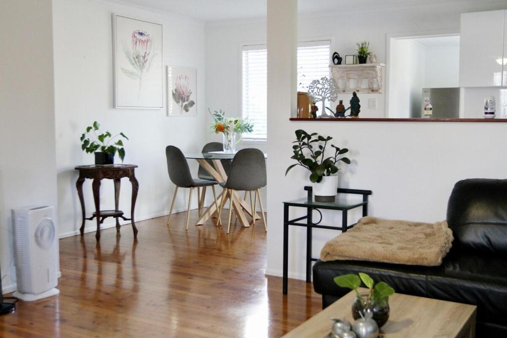 a living room with a couch and a table at Enchanted Garden, 3 bedrooms in Sandstone Point