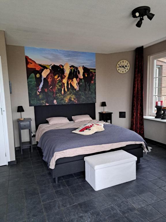 ein Schlafzimmer mit einem großen Bett und einem Gemälde an der Wand in der Unterkunft Dereshoeve in Bunschoten