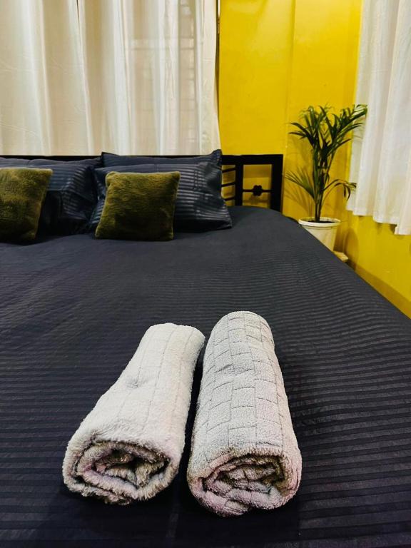 a bed with two towels on top of it at House Of Green Flag VIP ROAD Baguiati Kolkata in kolkata