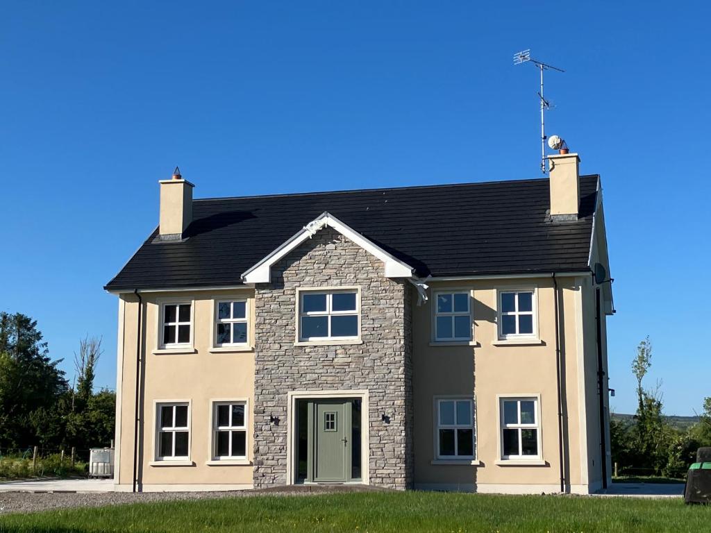 a large brick house with a black roof at Dannys Haven in Ballagh Cross Roads