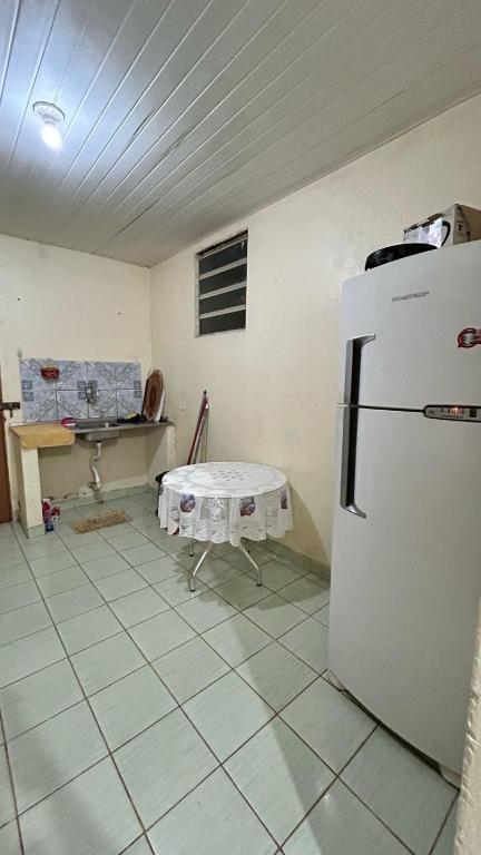 a kitchen with a white refrigerator and a table at Casa Aguiar in Santarém