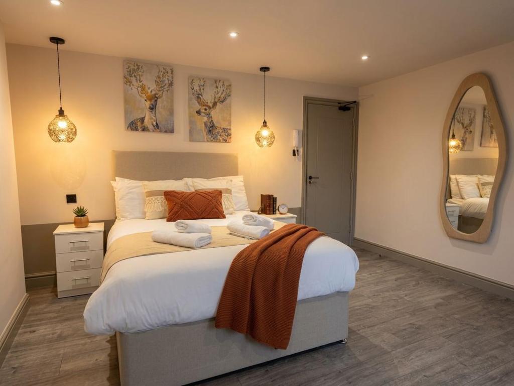 a bedroom with a large bed and a mirror at Clapton Station Luxury Studios near Central London in London