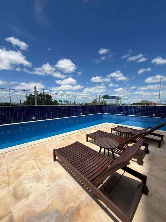 a patio with two picnic tables and a swimming pool at Prime BNB 1005 Experiência Premium in Petrolina