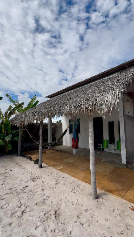a house on the beach with a straw roof at Varanda das Dunas in Santo Amaro