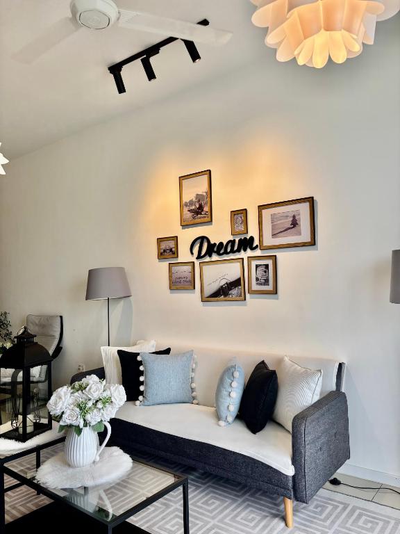 a living room with a couch with a dream sign on the wall at daisy apartment taiping in Taiping