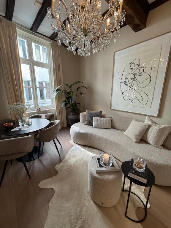 a living room with a couch and a chandelier at Boutique Apartment Perenne in Maastricht