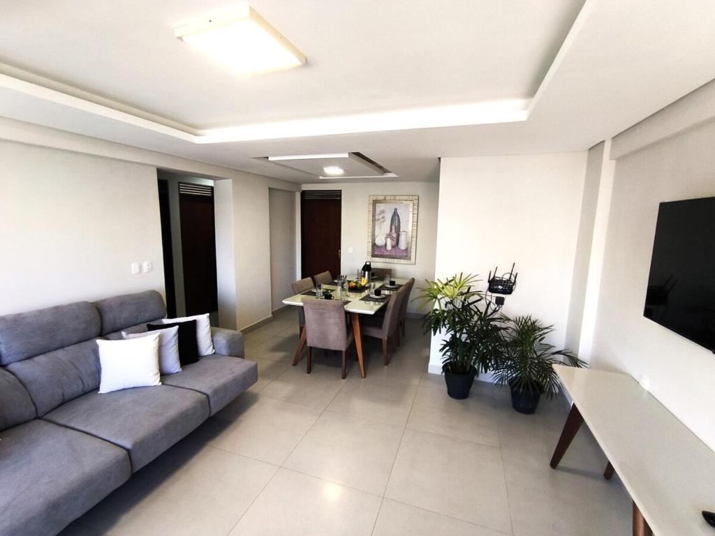 a living room with a couch and a dining room at Refúgio em Intermares, 250m do Mar com piscina in Cabedelo