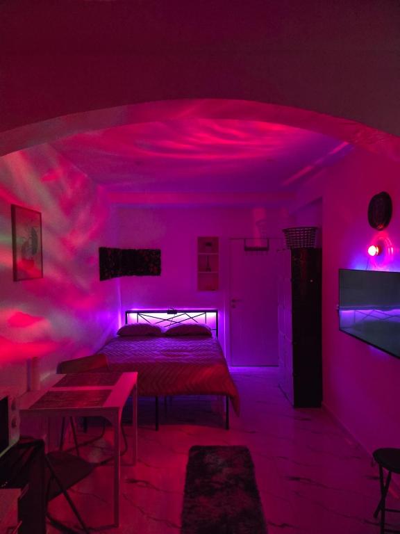 a bedroom with a bed with pink lights on it at Studio modern climatise in Bourgoin