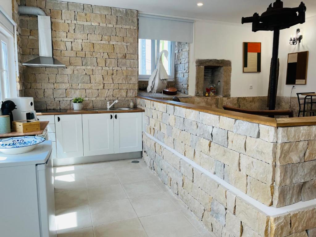 a kitchen with a brick wall and a sink at Largo de Santa Ana in Cadaval