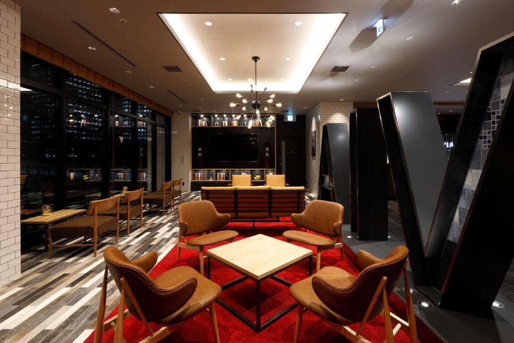 a restaurant with chairs and tables and a television at Via Inn Prime Osaka Kyobashi in Osaka