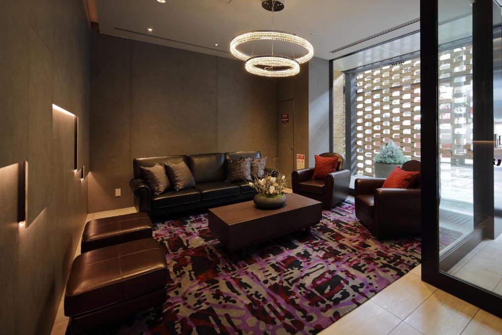 a living room with a couch and a table at Via Inn Umeda in Osaka