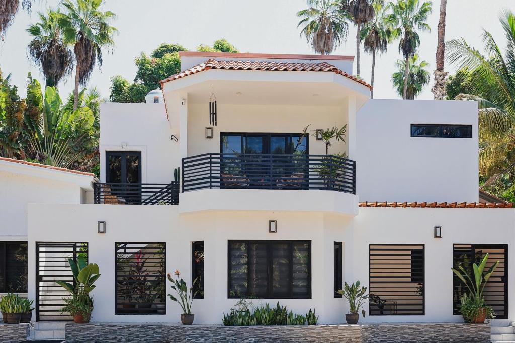 a white house with palm trees in the background at Casas Blancas, Planta Baja in Todos Santos