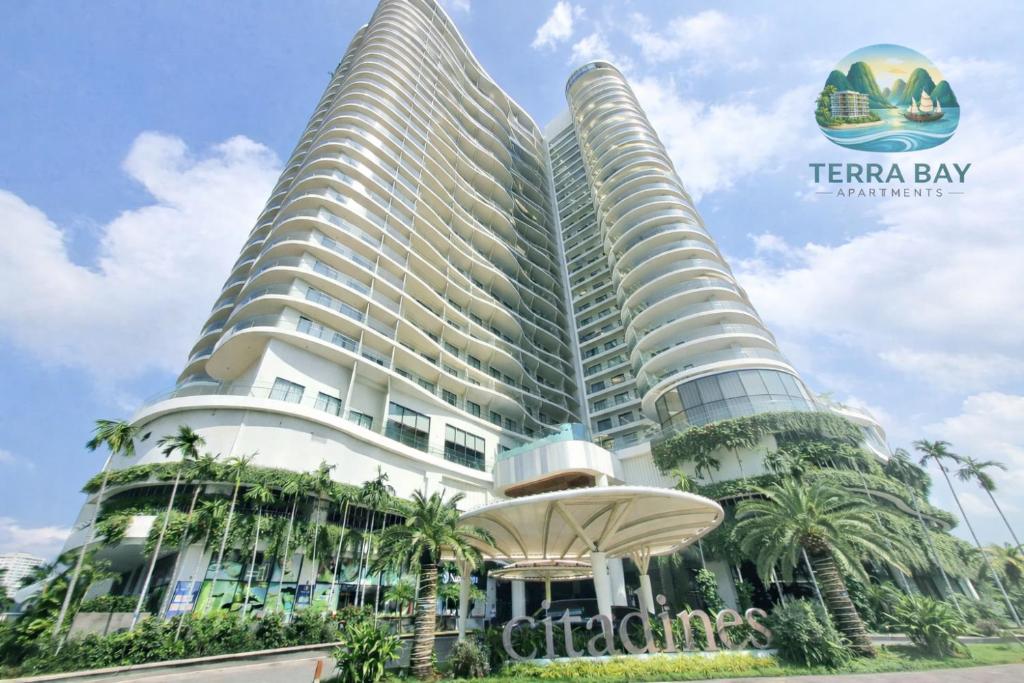 two tall buildings with palm trees in front of them at Terra Bay Homestay in Ha Long