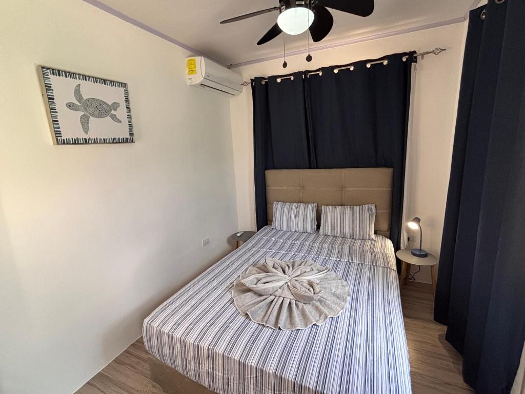 a bedroom with a bed and a ceiling fan at Orquídea de la Paz in Coco