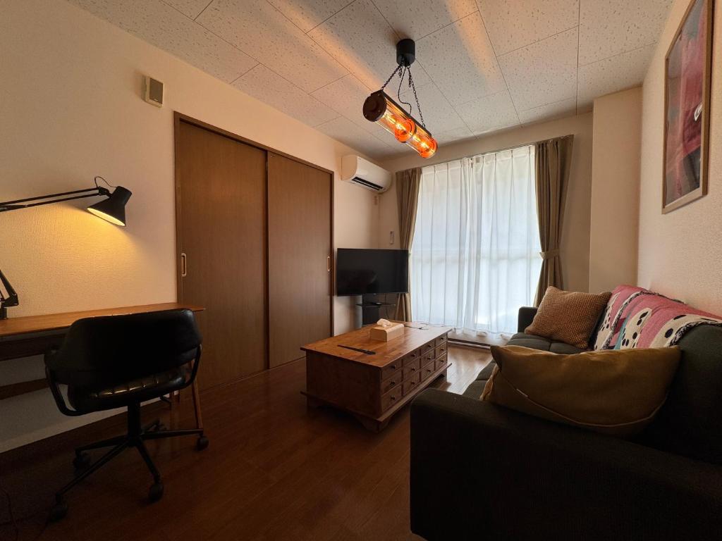 a living room with a couch and a table at BreakPoint in Ichinomiya