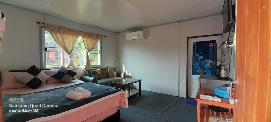 a bedroom with a large bed and a window at เล่าจู in Ban Na Yang