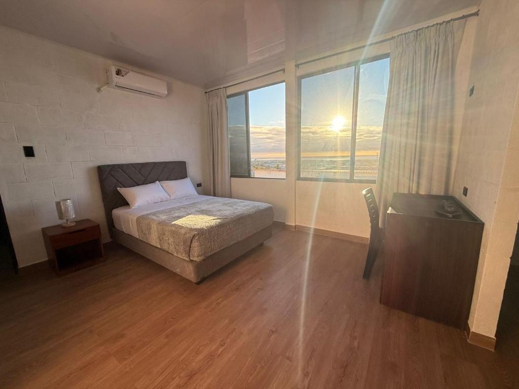 a bedroom with a bed and a large window at Hospedaje Zerimar in Puerto Baquerizo Moreno