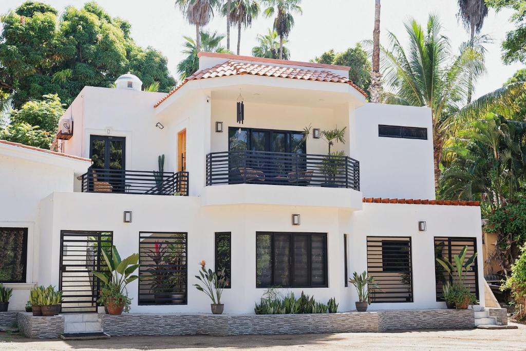 a white house with palm trees in the background at Casas Blancas, Planta Alta in Todos Santos