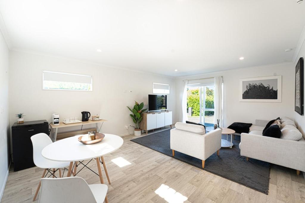 a living room with a couch and a table at Studio 17 Private Standalone Studio in Greenhithe North Shore in Auckland