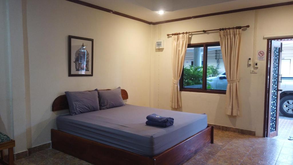 a bedroom with a bed and a window at Baanpuklertsuk in Ban Map Ta Put