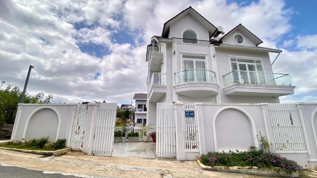 a white house with a white fence at Lộc Phú Villa - Hoanglee in Da Lat