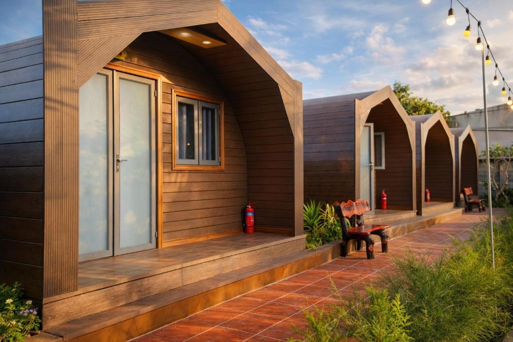 a home with a wooden porch with a bench at New Sky Homestay in Chợ Phước Hải