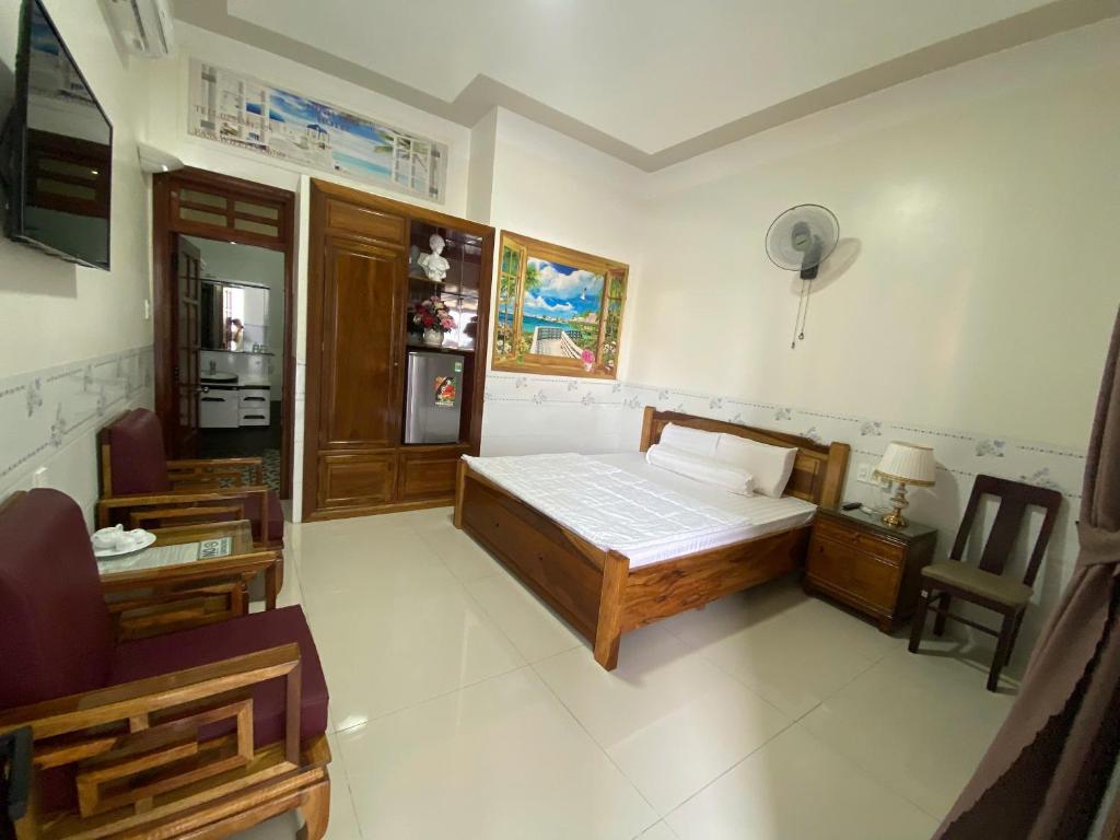 a bedroom with a bed and a chair in it at Khách Sạn Ninh Thọ in Quảng Ngãi