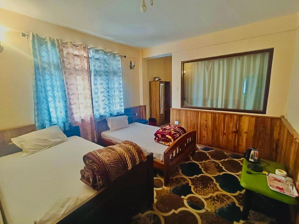 a bedroom with two beds and a window at Vedanth Retreat Homestay in Kalimpong
