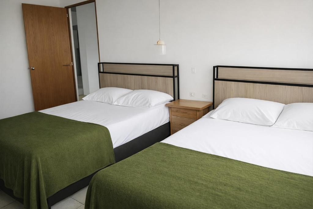 two beds sitting next to each other in a room at Aparta Suites Torre de Prado 601 Apartamento para 9 Personas in Medellín