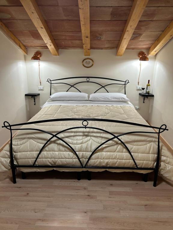 a bedroom with a large bed with wooden ceilings at la Tana di Luna in Adrano
