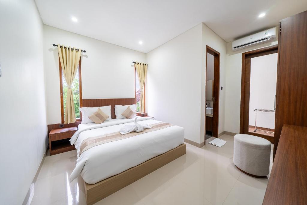 a bedroom with a large bed and a window at Dekade Living in Denpasar