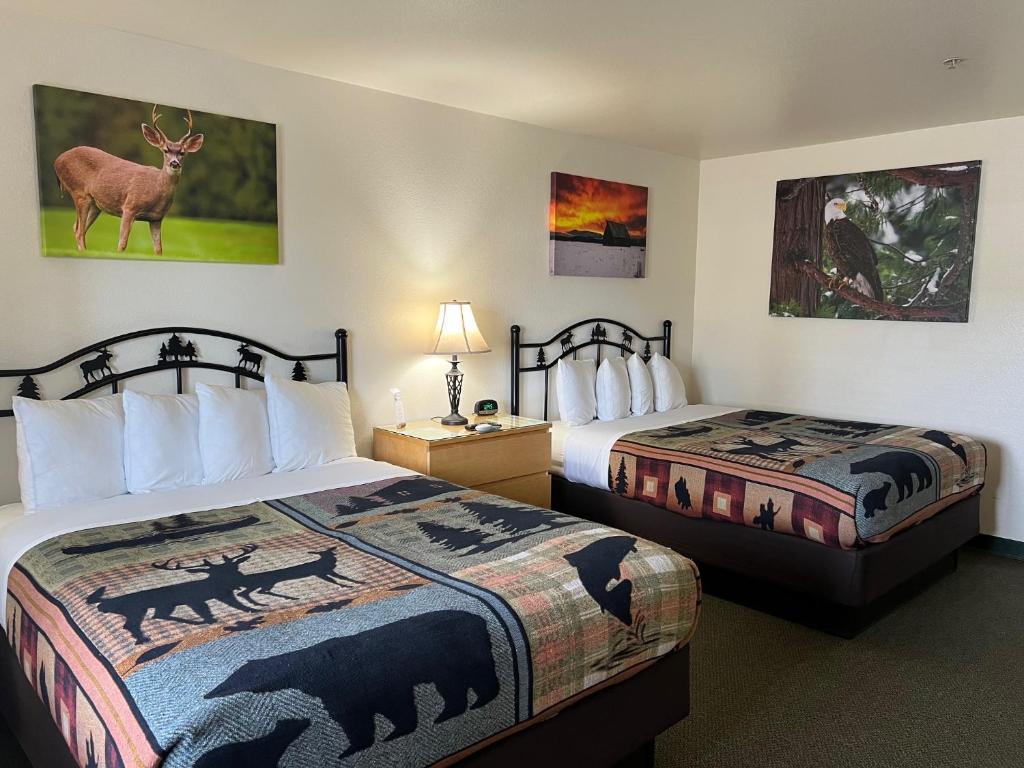 two beds in a hotel room with animals on the covers at Antlers Inn in Chester