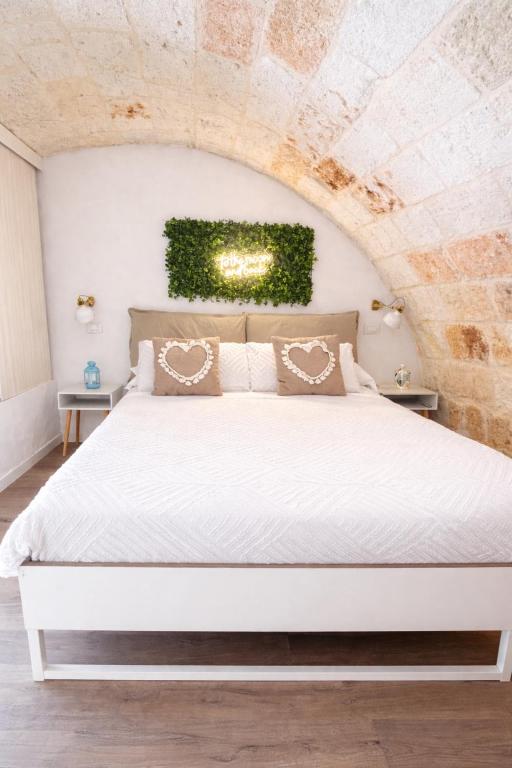 a white bed in a room with a brick wall at Stella Marina Luxury in Polignano a Mare