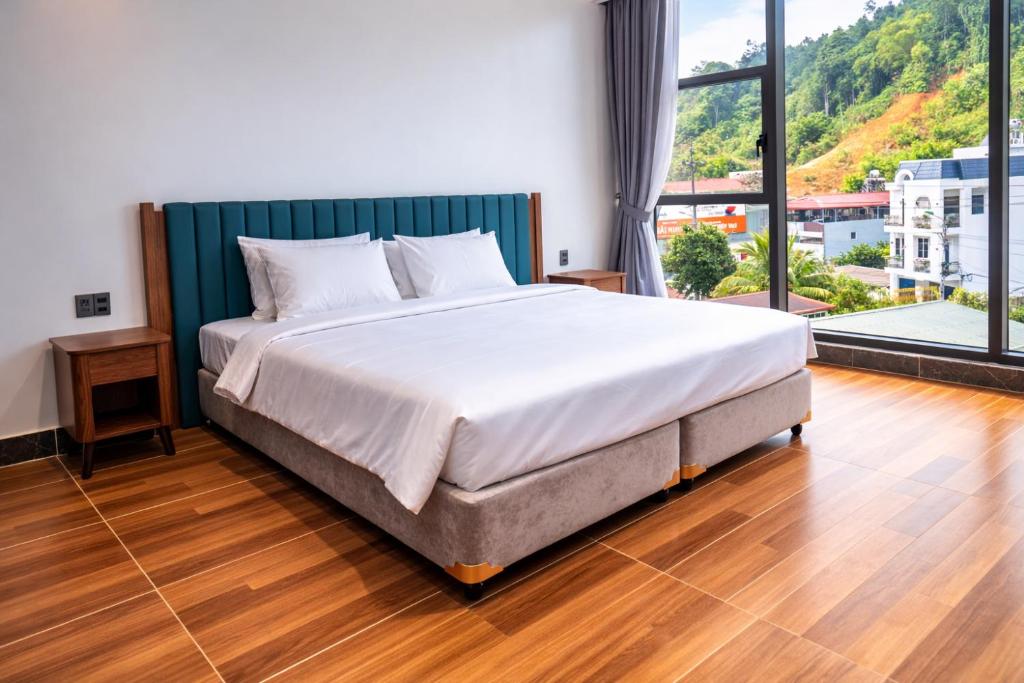 a large bed in a room with a large window at Ha Giang Numa Hotel in Ha Giang