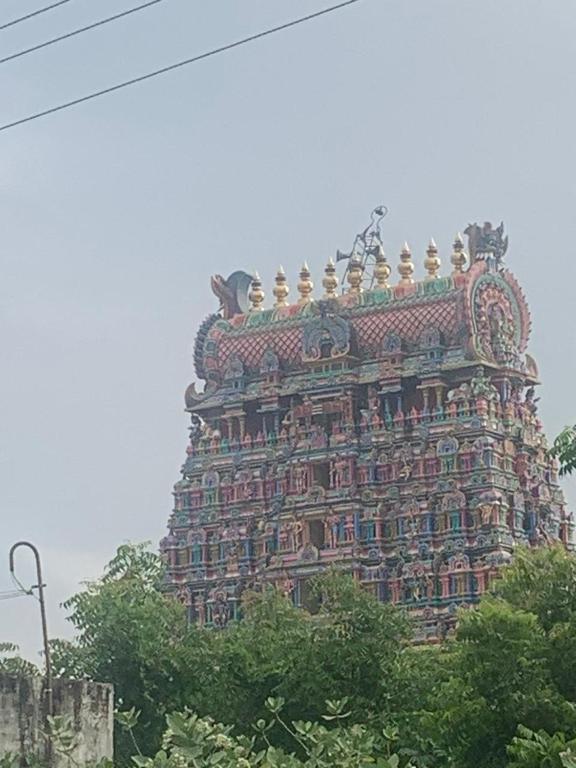 a tall building with a lot of decorations on it at abirami arulagam in Jāmb