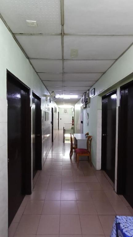 a hallway of a hospital with benches and a long corridor at Hotel Changlun B in Bukit Kayu Hitam