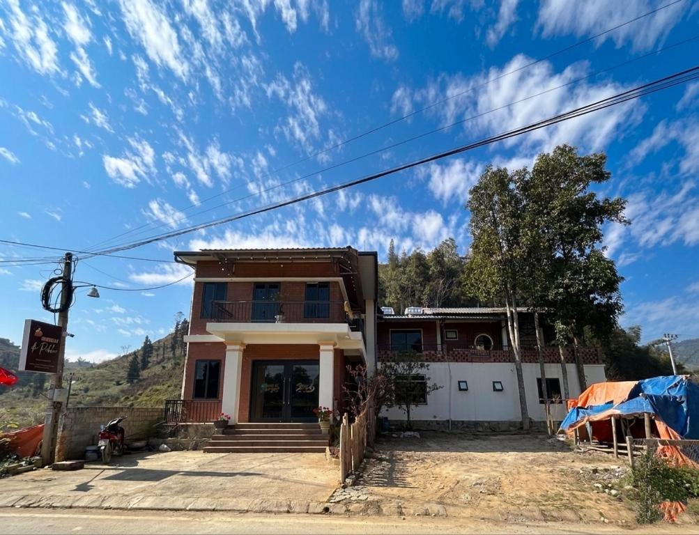 a house on the side of a street with a blue sky at De Pakha Homestay in Bắc Hà